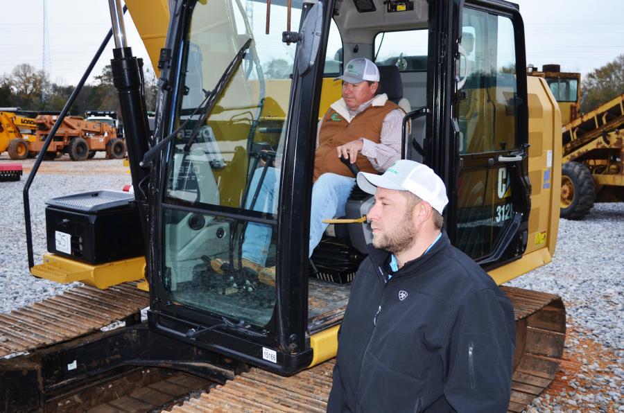 Test operating a nice Cat 312E excavator are Cam Lanier (in cab) and Mitch Cannon of Evergreen Siteworks, Opelika, Ala.  
