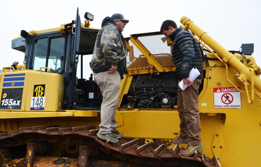Deep in discussion during a Komatsu dozer inspection are Burt Jeffords (L) and Jared Jeffords of Jeffords Grading, Calhoun, Ga.  
