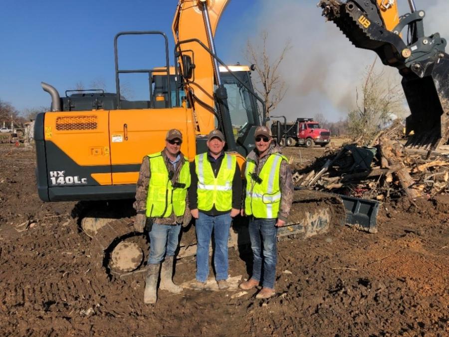 Hyundai covered the costs for shipping three excavators to First Choice Farm & Lawn for use in cleanup efforts in Samburg, Tenn. Ed Harseim, sales manager of the region, joined Don Parks (L) and Ron Parks (R), co-owners of First Choice, in the cleanup efforts.