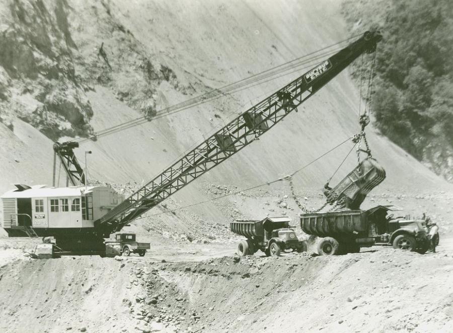 A Bucyrus-Erie 120B electric dragline loads a Mack Super Duty AP truck during construction of San Gabriel Dam north of Azusa, Calif., circa 1933. Built by the West Slope Construction Company joint venture, this was the world’s largest rockfill dam when completed in 1937. 
(Bucyrus-Erie Company photo/HCEA)