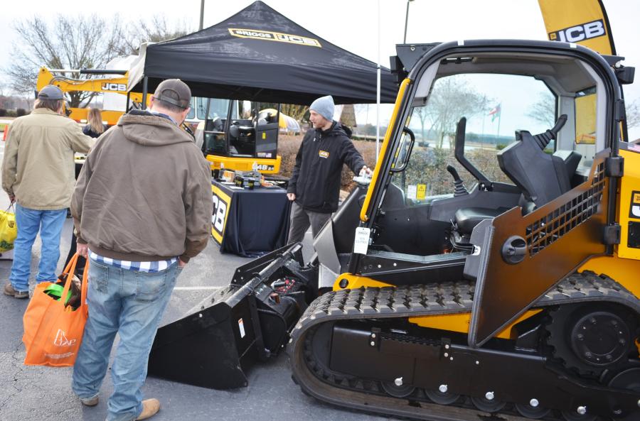 At the Briggs JCB outdoor exhibit, JCB’s Tyler Peterson (R) provides a machine walkaround of a JCB 270T compact track loader for a couple of public works representatives. 