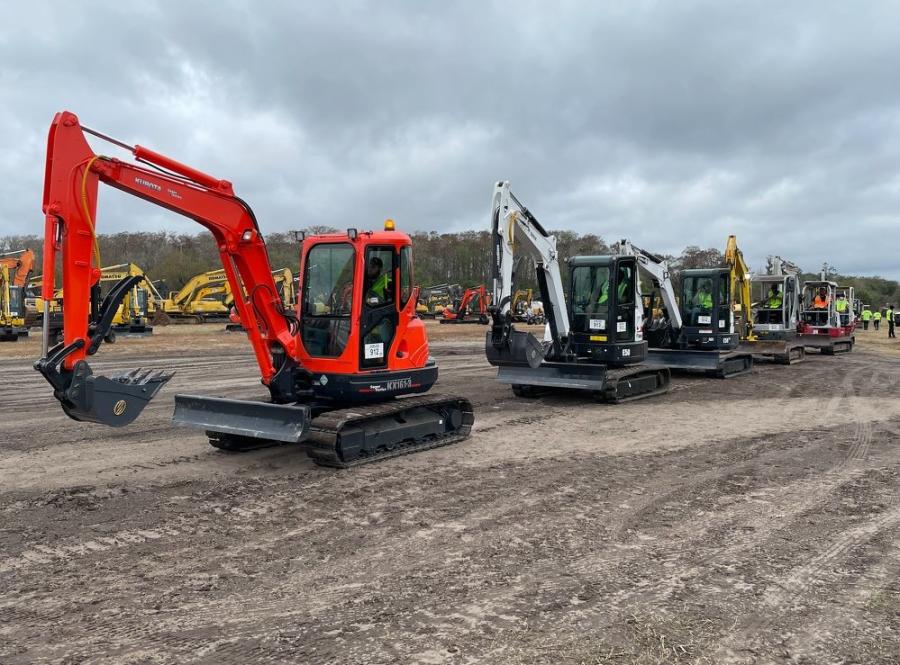 Compact excavators of all makes and models are lined up and ready to roll over the auction ramp.