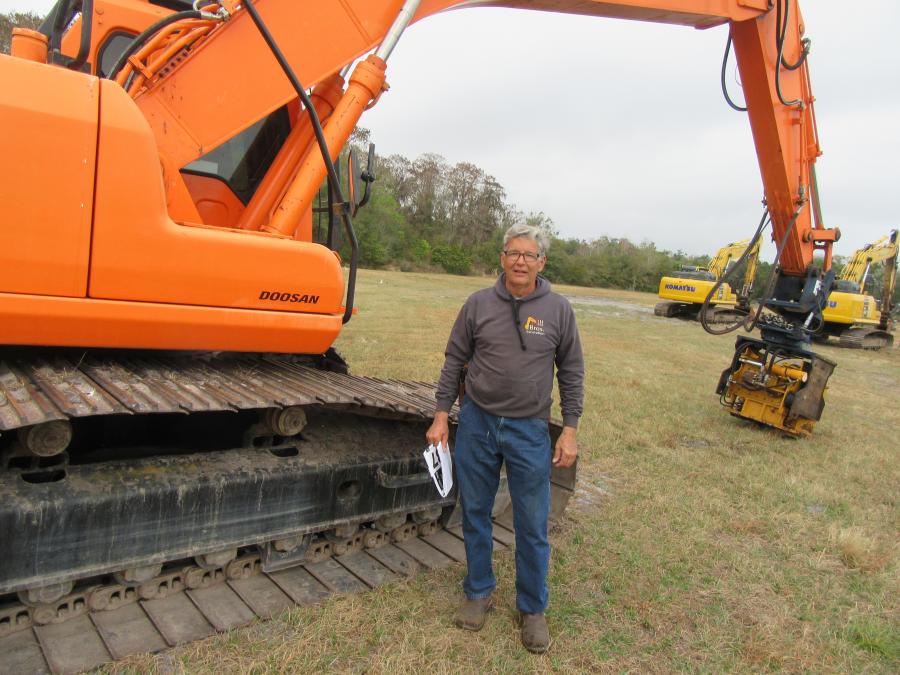 Joe Hill of Hill Brothers looks over this Doosan DX255LC excavator at the Yoder & Frey auction.