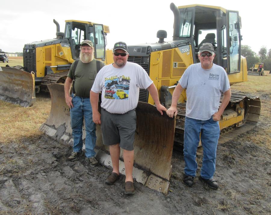(L-R): Jim Edmonds of CJ Trucking is joined by Ridgeline Equipment’s Rick Hooser Jr. and Rick Hooser Sr. to review the dozers.
