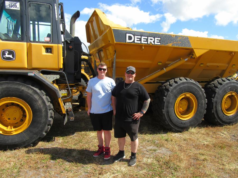 Reviewing this John Deere 250D articulated dump truck are Cole (L) and Blaire McIlmoyle of RA Crete Scape, of Toronto, Canada.
