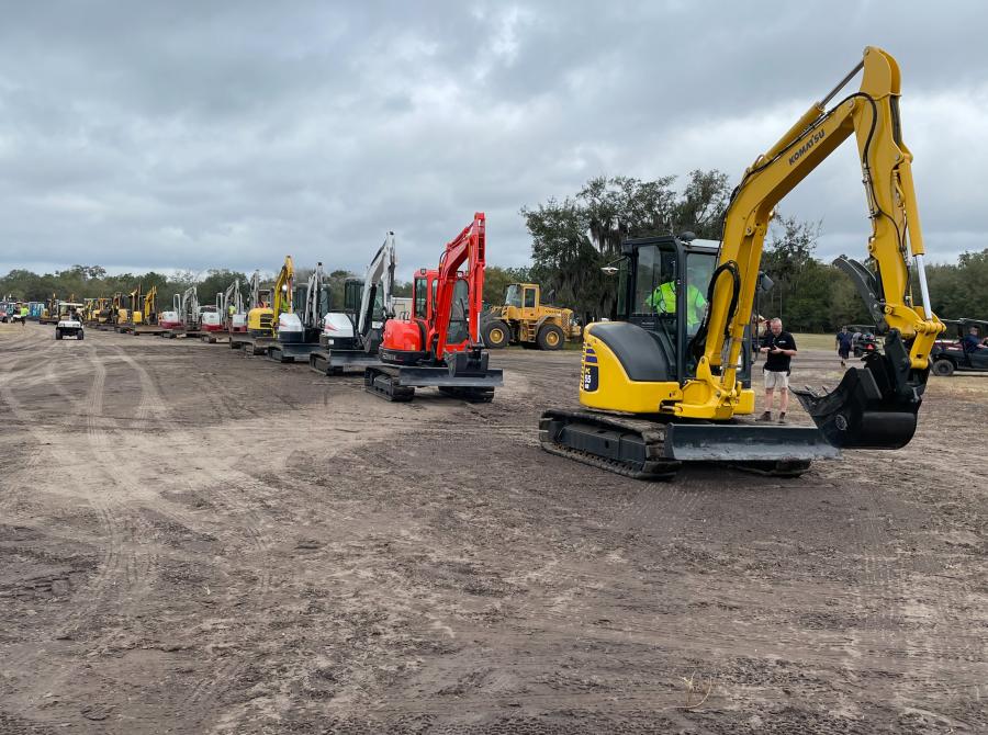 Compact excavators of all makes and models are lined up and ready to roll over the auction ramp.