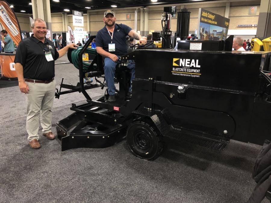 Tripp Farrell (L) of Neal, a division of Blastcrete Equipment in Anniston, Ala., and Brent Florence of Smith & Sons Sealcoating in Brookville, Ohio, are shown with the Neal DA350 dual sealcoat applicator.  