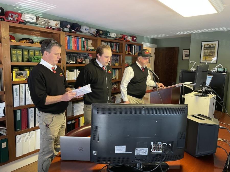 Mike Hunyady (far R) opens the auction and introduces auctioneer John Welch (C), while Tim Dewey looks through the auction catalogue.