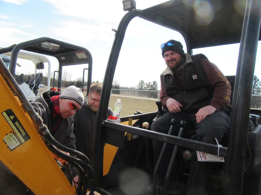 (L-R): Kevin Ternes, Austen Albrecht and Kyle Ternes of The Men of the Future Farms inspect this JCB 804 mini-excavator. 
