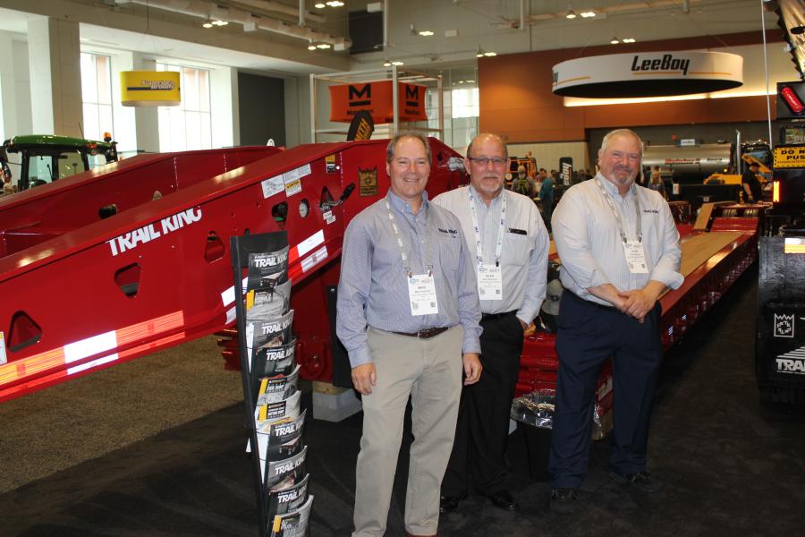 (L-R): Mike Heshke, director of international market development; Dean Badinger, product support manager; and John Denney, district sales manager, all of Trail King Industries, Mitchell, S.D., stand next to the company’s    TK102HDG hydraulic detachable gooseneck paver special.