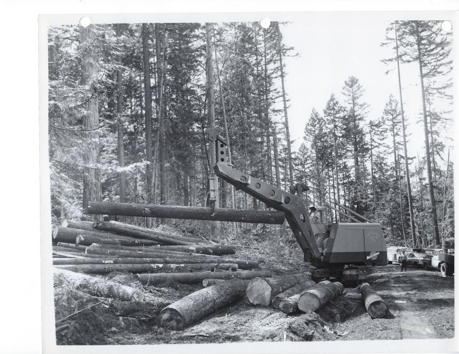 A Manitowoc 2300, owned by Lattimer & Sons Logging Company Inc., handles logs with a Young heel boom. As shown here, the lower angle of the boom provided a point of contact to stabilize the log and the tong lifting it against swinging or rotating. Note the elevated cab. 
(Manitowoc Company photo/HCEA)