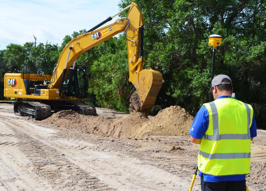 Mike Hinz of the U.S. Army Corps of Engineers, based in Clewiston, Fla., operates a Cat 326 excavator with Grade Control to makes a run at the excavator challenge as Archie Justiniano (R) of SITECH waits to check the grade of the final dig. 