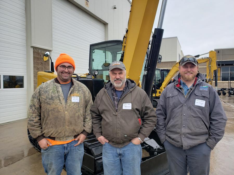 (L-R): Grandon and Gordon Scheil, both of Scheil Construction; and Chandler Erickson of Bac Earthworks LLC had a look at this Cat 308 excavator.
