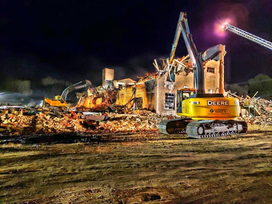 A John Deere 270D with 60-ft/-long reach working at a demolition site.