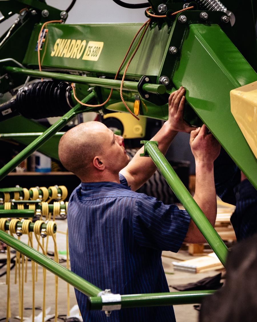 Dalton Himmelberger, service technician, is working on a Krone Swadro hay rake.