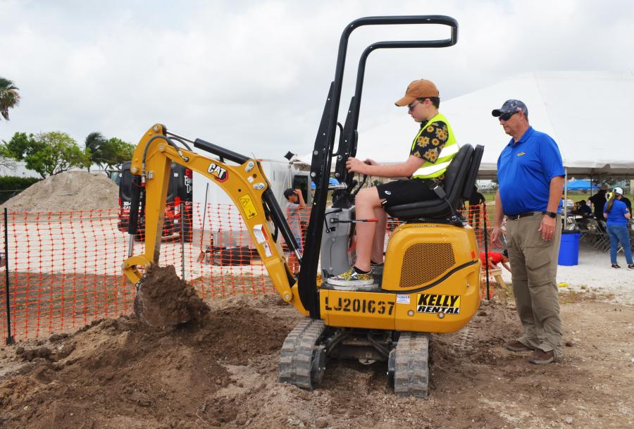 Kelly Tractor’s Jim Keegan (R) provides some operating instruction to Eduardo Lanza, a young Cat equipment enthusiast and the son of a Caterpillar staffer. 
(CEG photo)