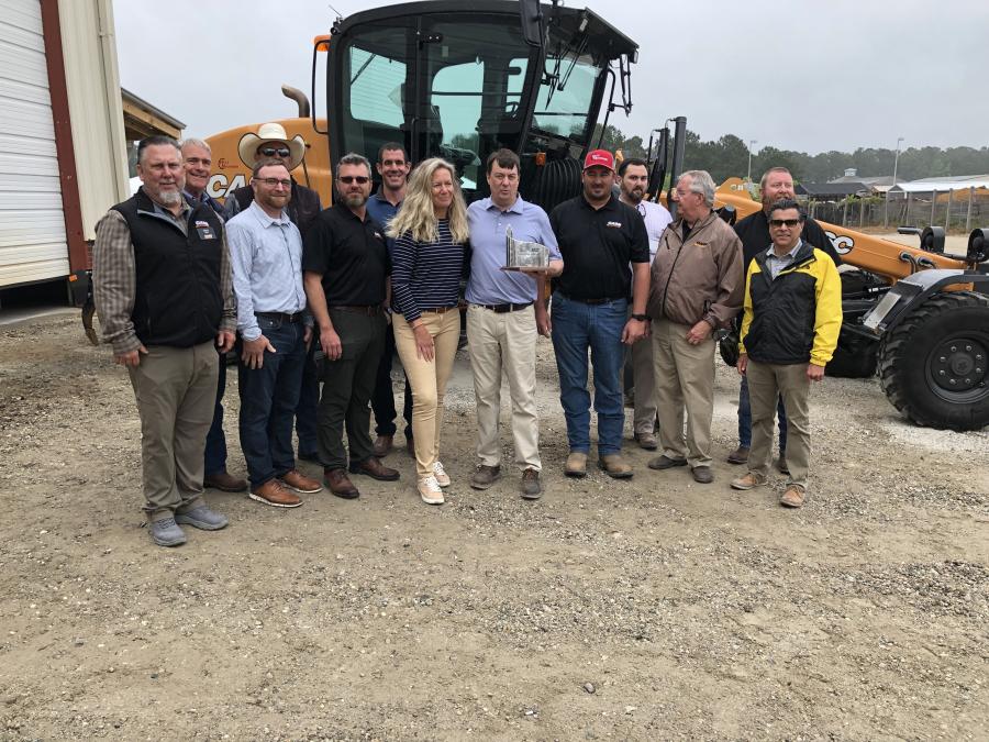 Part of the Hills Machinery team that made the ninth location possible gather around as Beth Bartow of Case gives Adam Hills the gift.
(CEG photo)