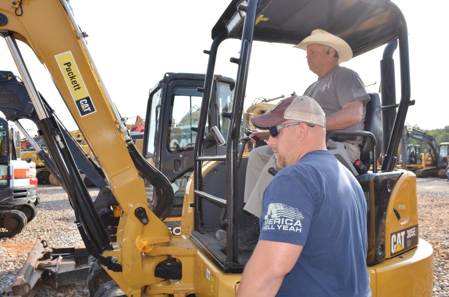 Test operating a Cat 305E mini-excavator are C.B. Smith (L) and Ken Meeks (in cab) of M&M Portolets, Thomasville, Ala.  
(CEG photo)