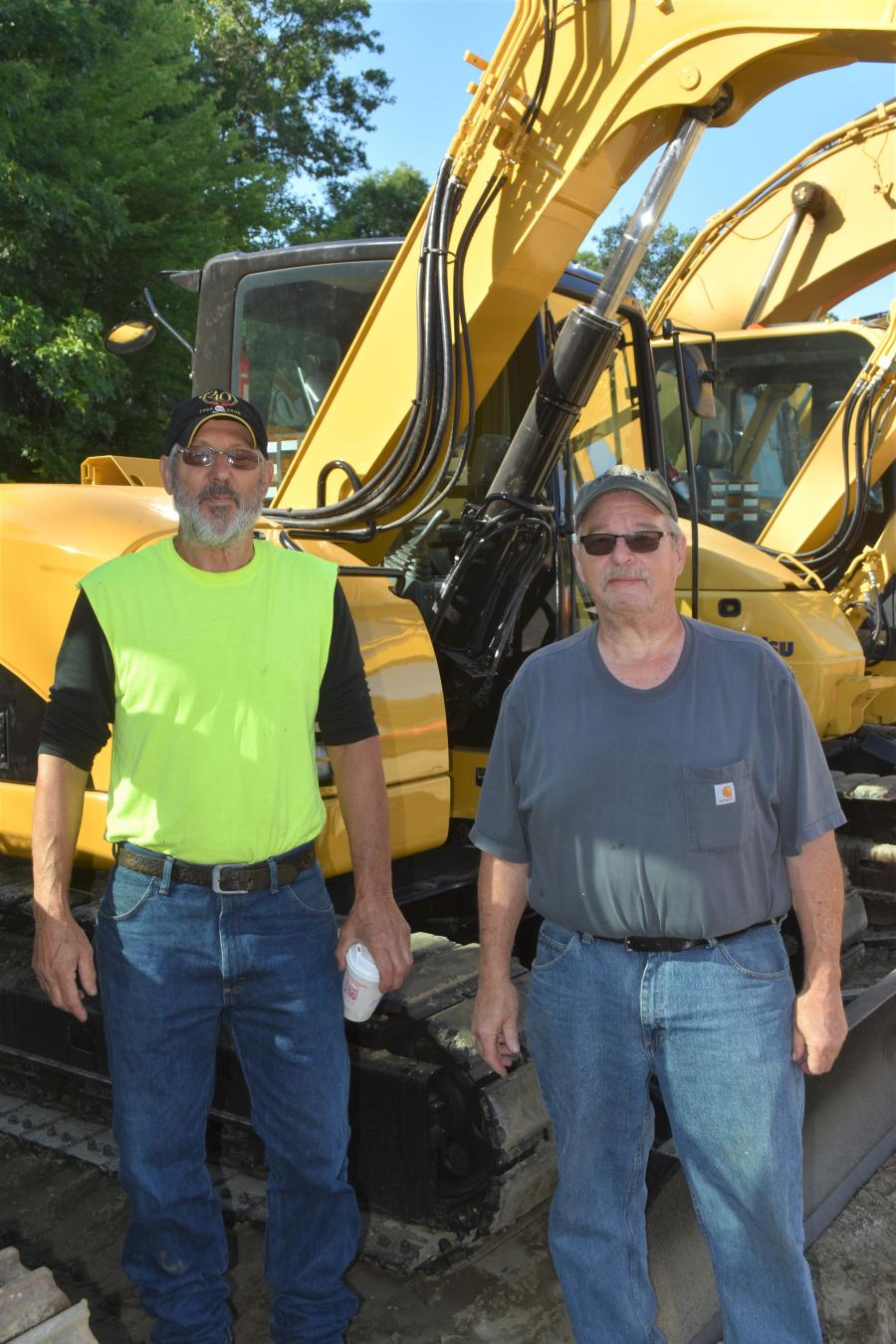 Douglas Deptula (L) and Ron Ethridge of Columbia, Conn., check out the great lineup of used excavators.
(CEG photo)