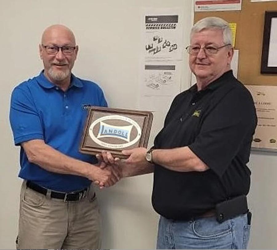 Mike Kornegay (R) of Eastern Wrecker Sales, Clayton, N.C.,  received the Landoll Dealer Salesperson of the Year award from Jim Ladner, Landoll Trailers sales manager.