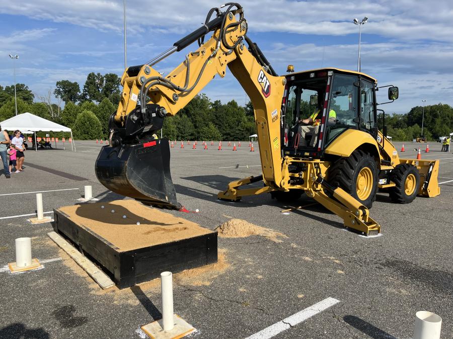 The contestants carefully picked the golf ball out of the sand with the spoon and placed it in the cup using this Cat 420 backhoe from Carter Machinery. (CEG photo)