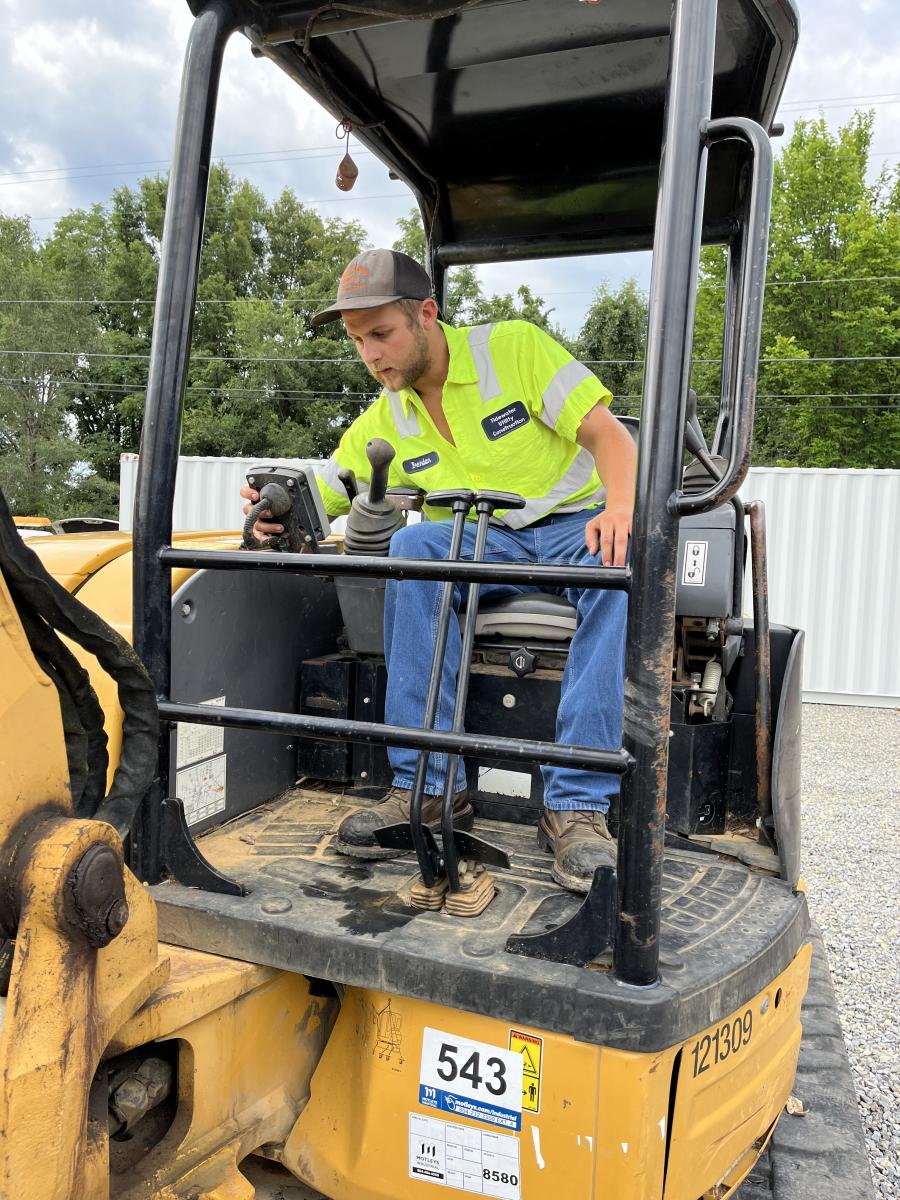 Brendon Johnson of Tidewater Utility Company in Suffolk, Va., checks the service history, hours and other items on this Cat 305.5 excavator. (CEG photo)