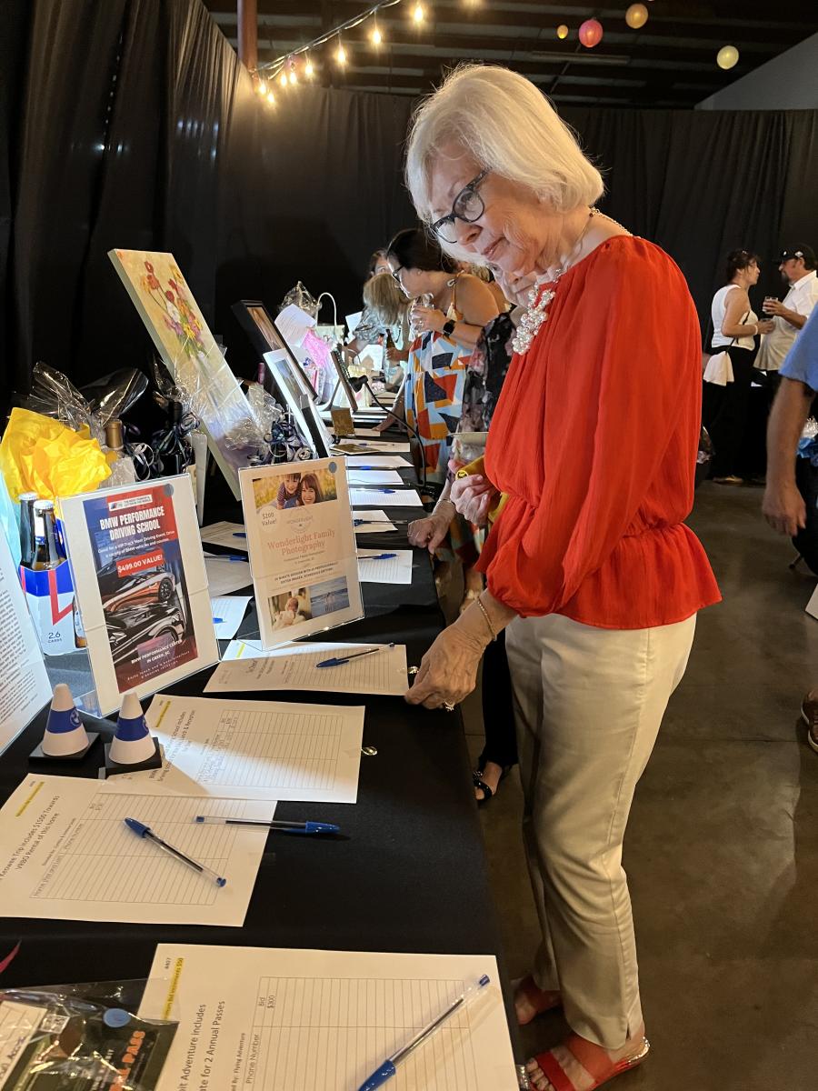 Judy Madaus of Calder Brothers looks over the silent auction items. (CEG photo)