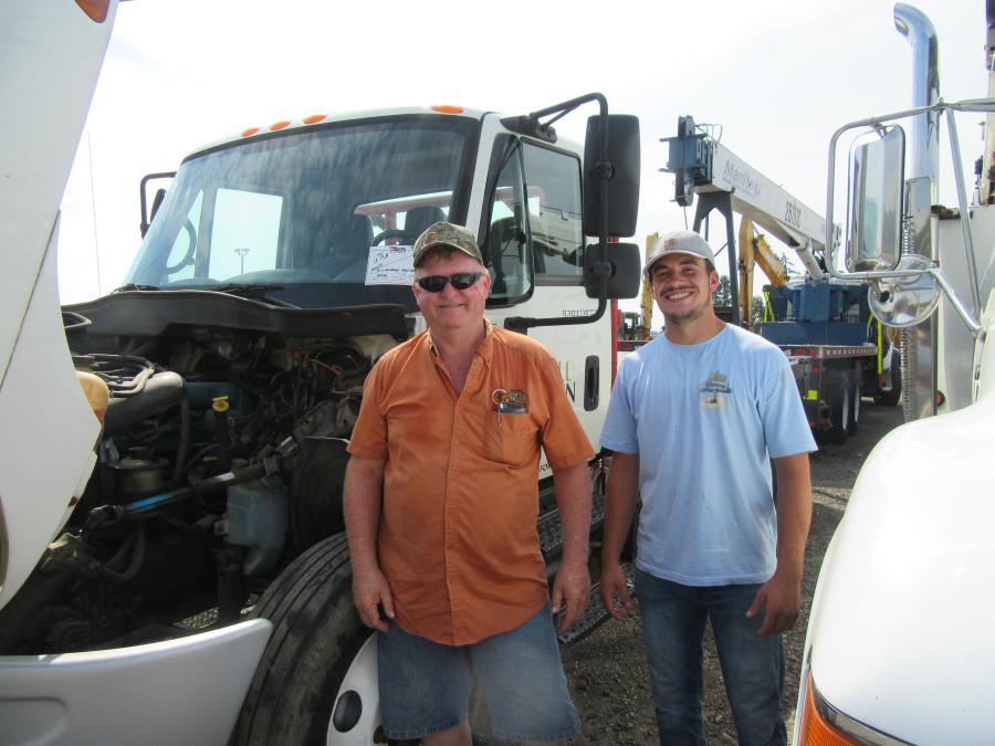 Having landed the winning bid on a utility tractor, Todd Myers (L) and Nick Webb of Kenneth Myers Construction look to add a truck to their auction purchases. (CEG photo)
