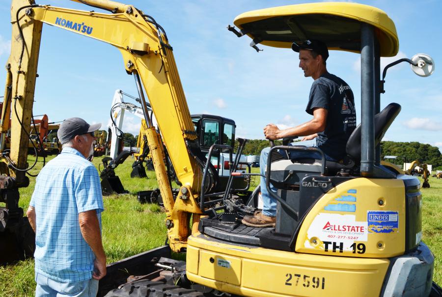 Deep in discussion on how a Komatsu PC50mr mini-excavator performs during a quick inspection are Edward Stilp (L) and Nathan Hill of Hill Bros. Excavation, Hartly, Del. (CEG photo)