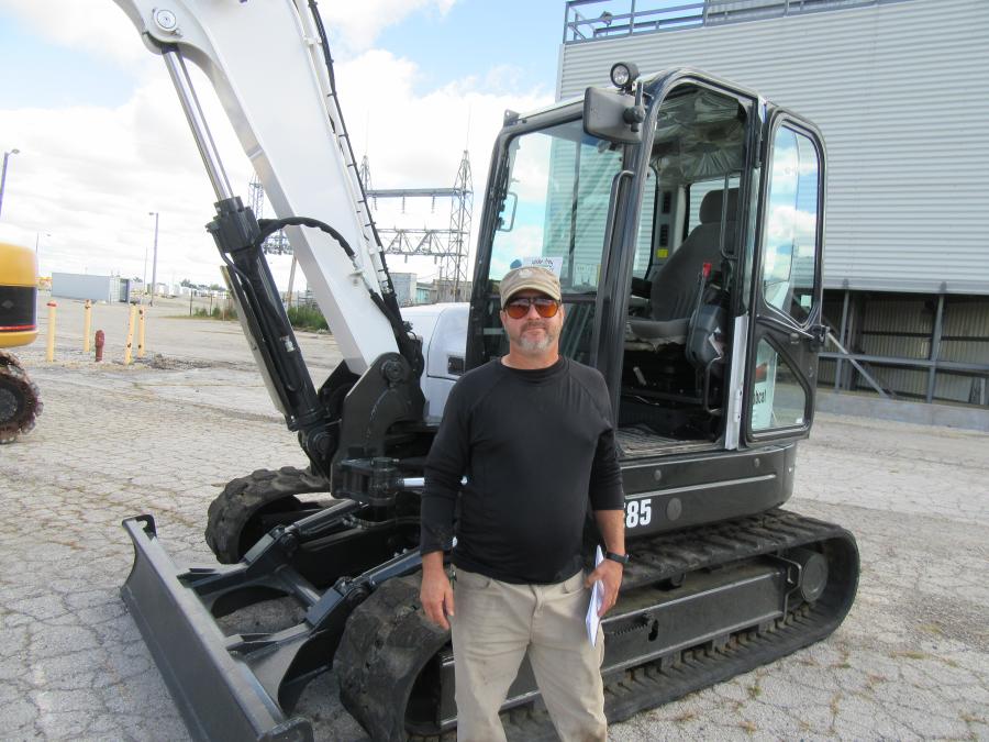 Luke Young of the Bluffton Golf Club considers a bid on this Bobcat E85 mini-excavator.
(CEG photo)