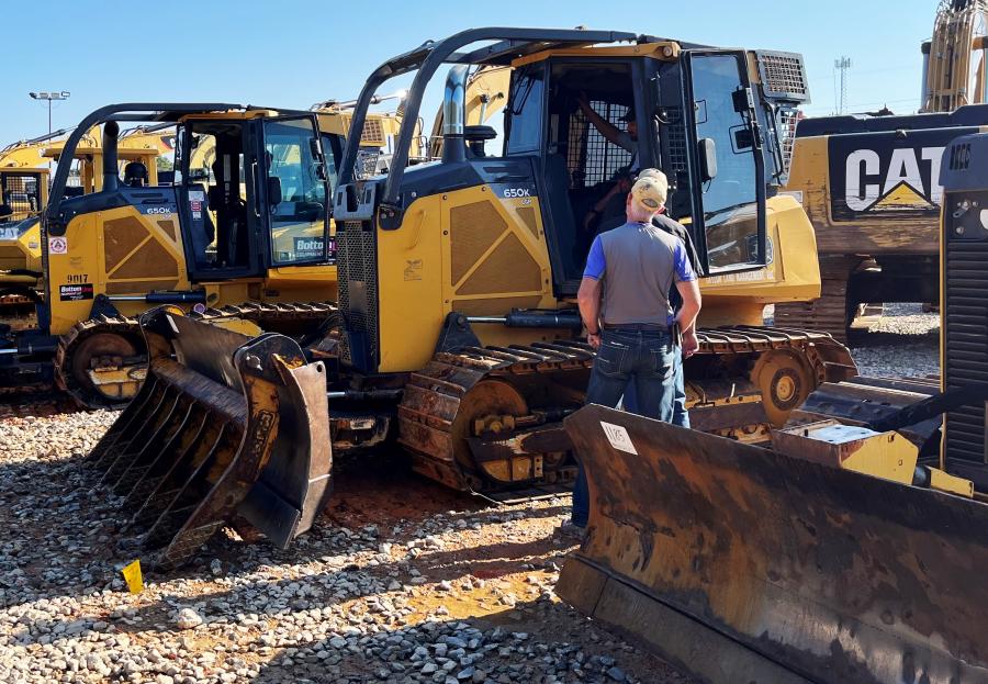 Cody Folsom, and Peter and Jay Durrence, all of Glennville, Ga., look over some Deere 650K dozers of interest.
(CEG photo)