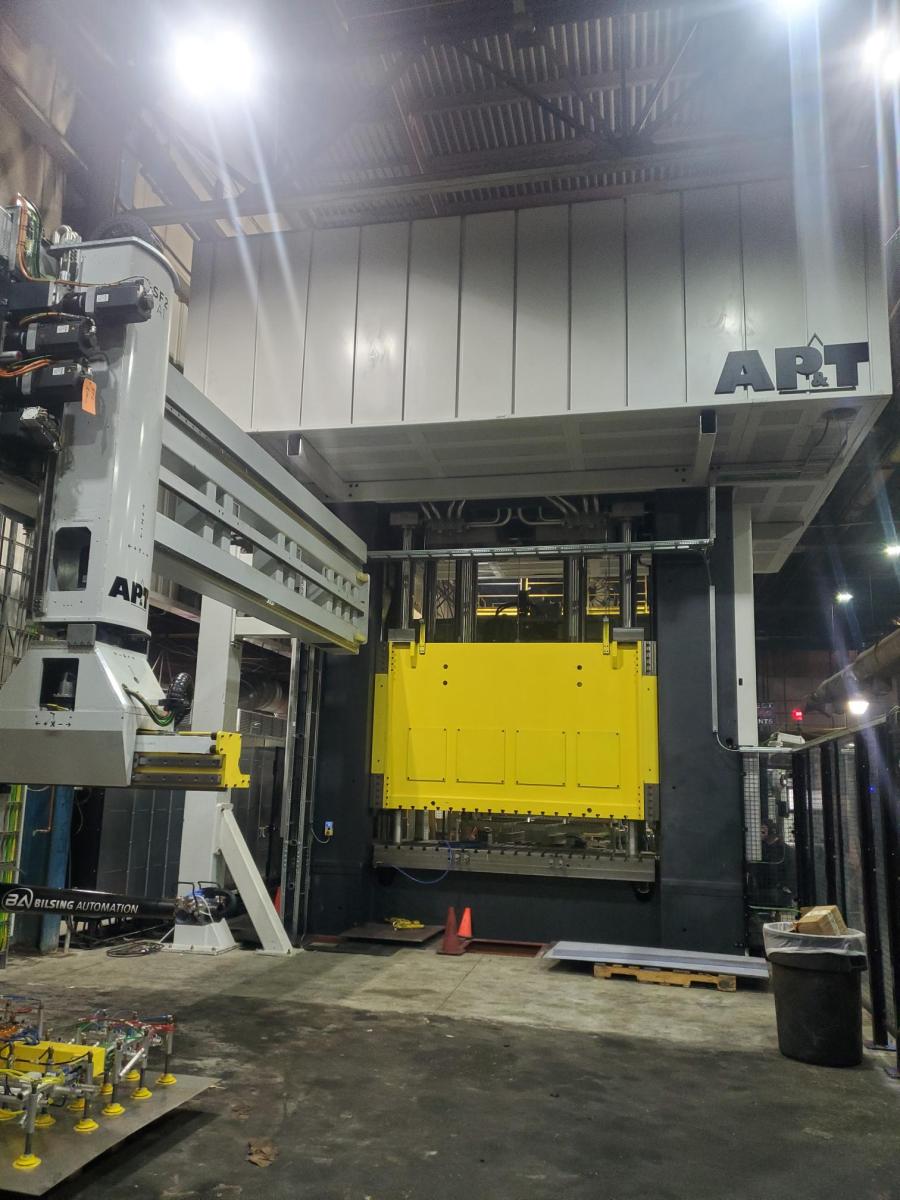 Shown from the unload side, the 2000 Ton AP&T valveless servo press towers above the floor. The AP&T servo transfer arm shown here lifts parts in excess of 200 lbs. and transfers them to the next press in the tandem line.