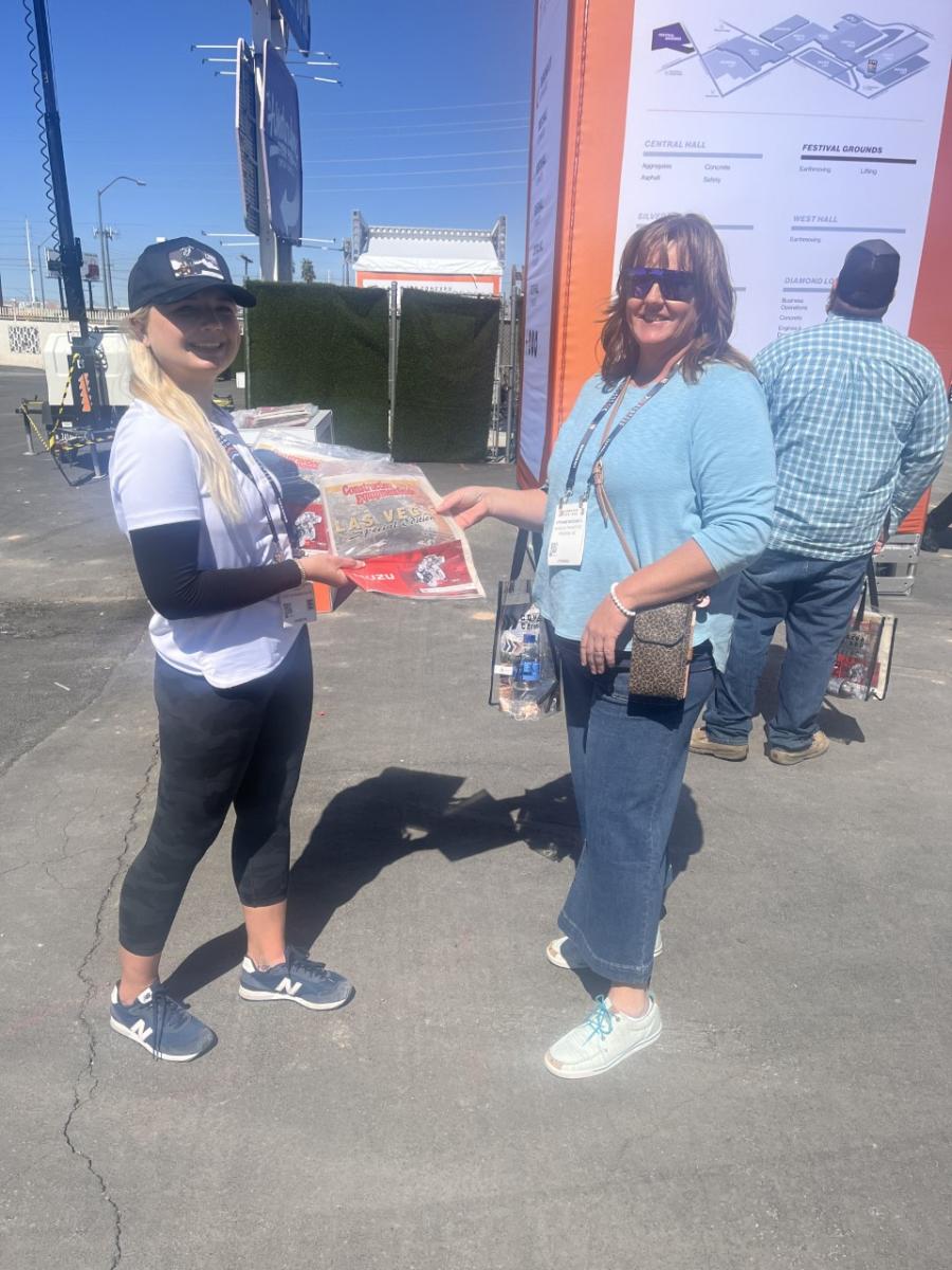 Jennifer Wardach (L) hands the Special Edition ConExpo Construction Equipment Guide to Stefanie McDowell of Mardian Transport, Phoenix, Ariz. 