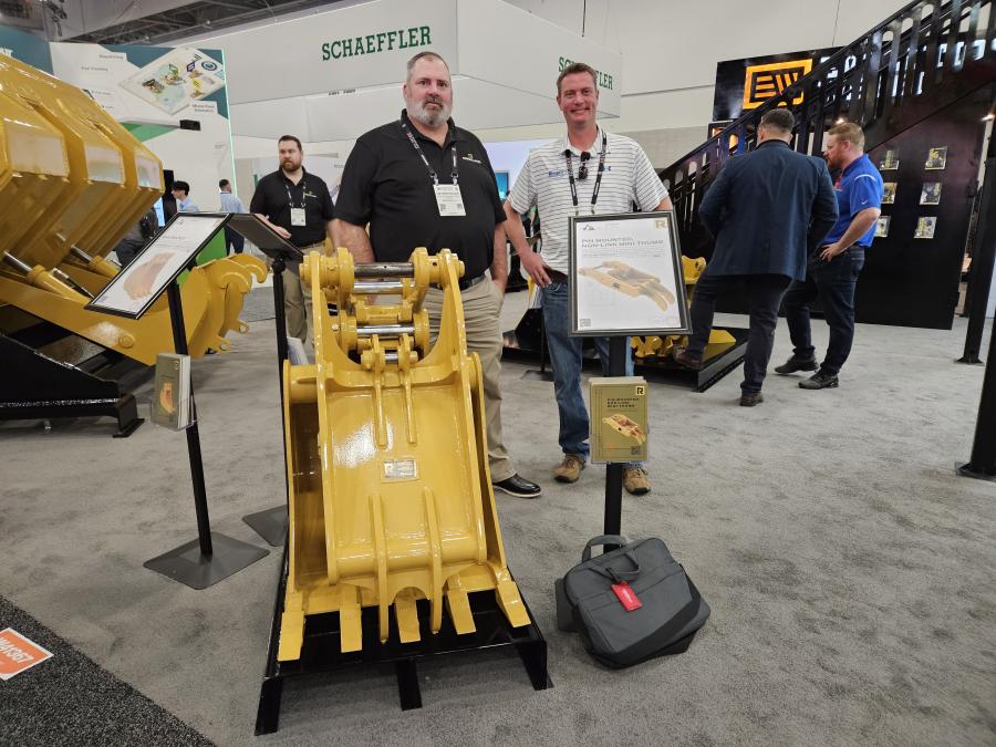 At the Rockland Manufacturing Booth with this pin-mounted non-link mini-thumb compact excavator attachment are Jim Hershberger (L) of Rockland Manufacturing, Bedford, Pa. and Shelby Whitley of Kirby-Smith Odessa, Texas. 