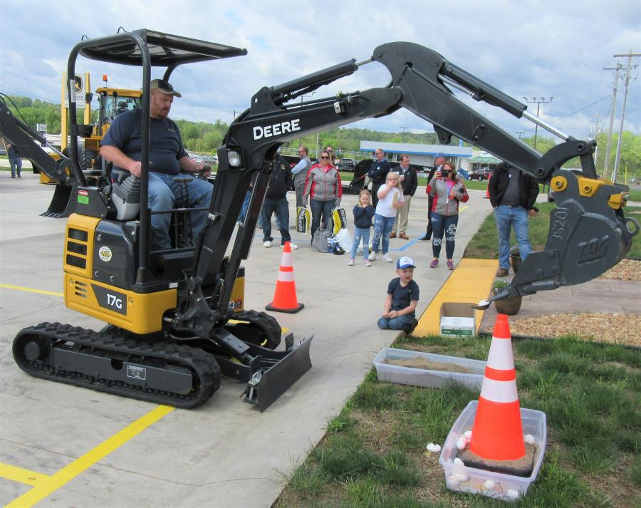 Second-Hand Tradition Logging Company’s Lindsey Collins (L) is cheered on by his son, Lincoln, as he tests his skills with this John Deere 17G compact excavator.
(CEG photo)
