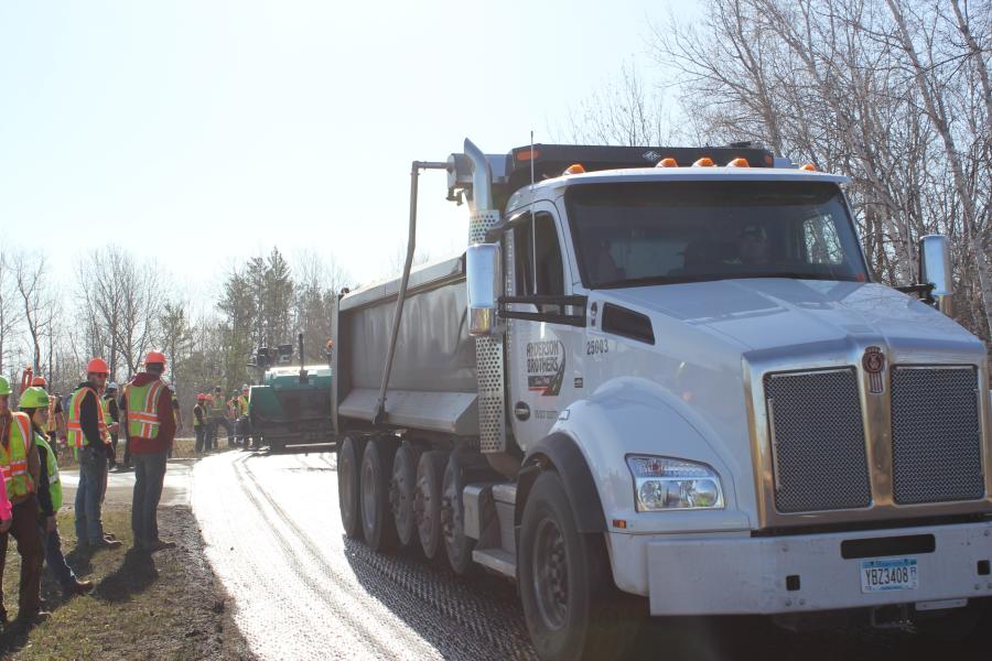 A truck from Anderson Brothers backs in with hot asphalt ready to be poured. 
(CEG photo)