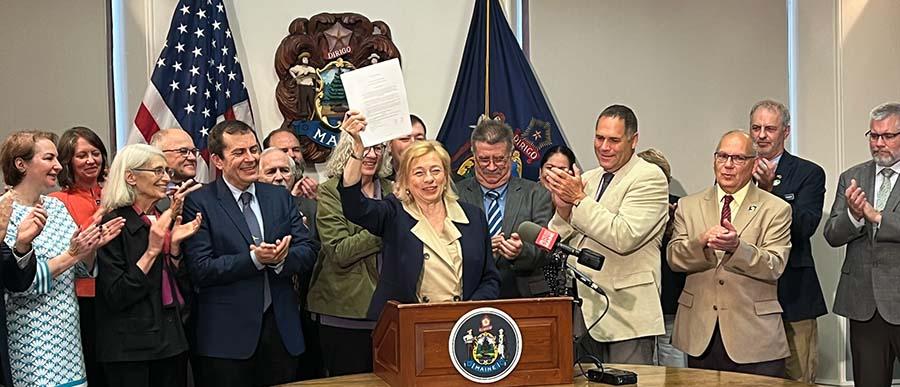 Legislators from both sides of the aisle stood behind Gov. Janet Mills as she inked the budget.  (Maine.gov photo)