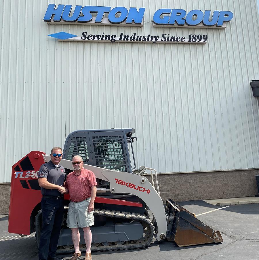 Carl Stickels (L), Northeast region business manager for Takeuchi-US, and Mark Butler, president of Butler Equipment, celebrate their companies’ new partnership next to Butler’s personal Takeuchi TL250 compact track loader.