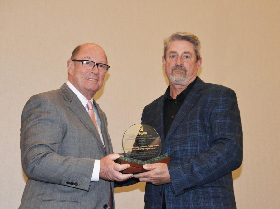 Judge Barry Hyde (L), Pulaski County, Ark., county executive, accepts on behalf of the county FP2's James B. Sorenson Award for Excellence in Pavement Preservation from FP2 president Mark Ishee, at National Pavement Preservation Conference 2023 (NPPC23) in September 2023.