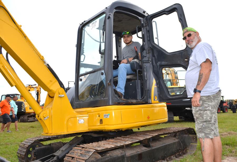 Interested in the mini-excavators about to go on the auction block are Chris Russo (in cab) and John Russo of JA Russo Contracting, Palm Bay, Fla. 
(CEG photo)